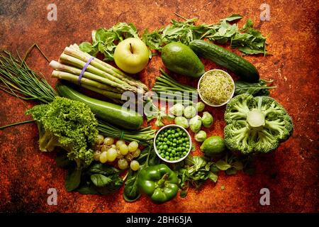 Fresh green vegetables and fruits assortment placed on a rusty metal Stock Photo