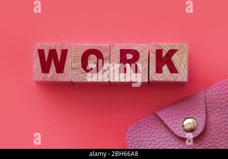 Workword made with wooden blocks and wallet on pink . Job salary money freelance concept Stock Photo