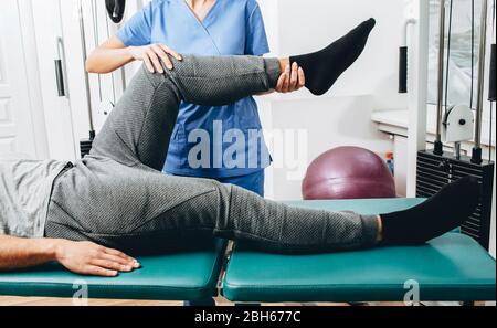 Joint, knee and leg pain treatment. physiotherapist doing treatment exercise patient's knee close-up Stock Photo