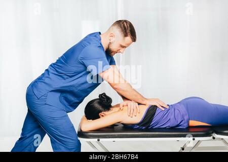 Physiotherapist giving back massage to female patient Stock Photo