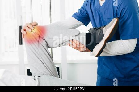 Joint, knee and leg pain treatment. physiotherapist doing treatment exercise patient's knee close-up Stock Photo