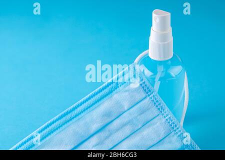 Medical mask and sanitizer on a blue background. Stock Photo