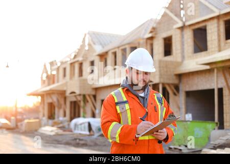 Architect writing in notebook on construction site. Stock Photo