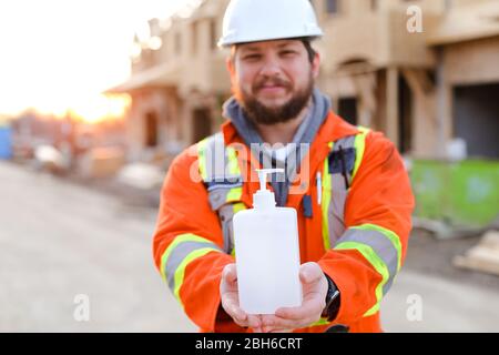 Focus on disinfectant soap given by engineer at construction site. Stock Photo