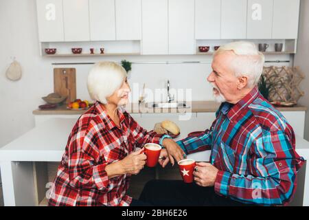 breakfast old people, elderly men and women drink together latte, being at home in the kitchen Stock Photo