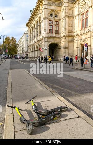 VIENNA, AUSTRIA - NOVEMBER 2019: Two scooters left in the middle of a pavement on a street in Vienna city centre. Stock Photo