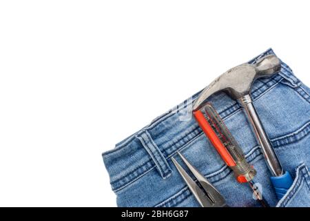 Jeans, screwdriver, hammer and pliers on white background. Jeans texture, Blue denim jeans with tools. Copy space concept Stock Photo