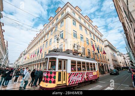 Lisbon, Portugal. January 04, 2019: Road crossing in the historic center of Lisbon in Portugal. The red tram crosses the city among the historic build Stock Photo