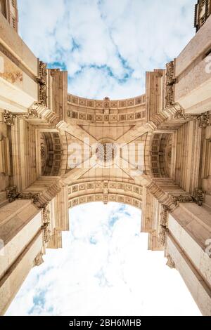 Detail of Rua Augusta triumphal Arch in the historic center of the city of Lisbon in Portugal. Blue sky with clouds. Perspective from the road. Stock Photo