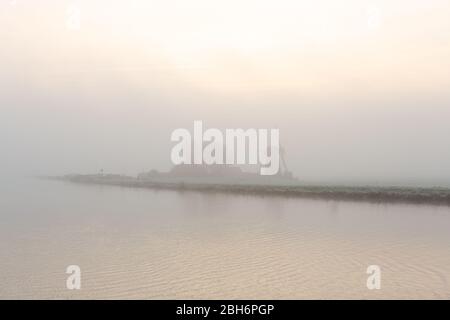 Windmill 'the Adermolen' on a foggy morning over the Ringvaart canal in Abbenes, the Netherlands. Stock Photo