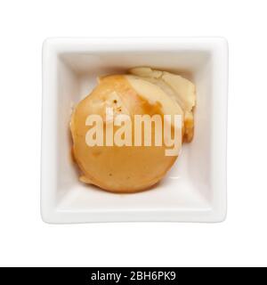 Serving of mashed potato with gravy in a square bowl isolated on white background; Stock Photo