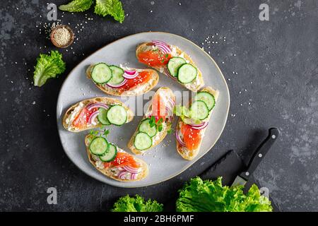 Sandwiches with homemade ciabatta bread, salted salmon fish, feta cheese, cucumber, onion and fresh lettuce salad Stock Photo