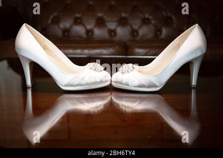 Luxury Wedding Shoes sitting on a reflective surface Stock Photo