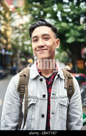 Portrait of young Vietnamese man with backpack in the city Stock Photo