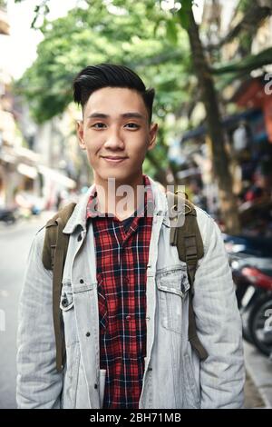 Portrait of young Vietnamese man with backpack in the city Stock Photo