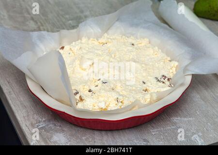 raw cottage cheese casserole dough in a round ceramic baking dish Stock Photo
