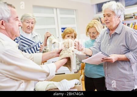 Old people as volunteers help to donate clothes for the needy Stock Photo