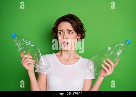 Photo of beautiful shocked lady hold plastic bottles trash recycling service sad people can't stop pollute land planet ocean water wear white t-shirt Stock Photo