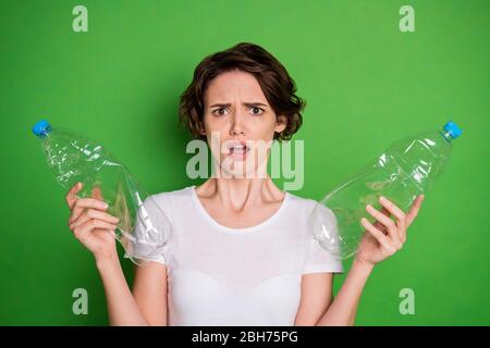 Photo of beautiful shocked confused lady hold plastic bottles recycling service sad people don't stop pollute land planet ocean water wear white t Stock Photo