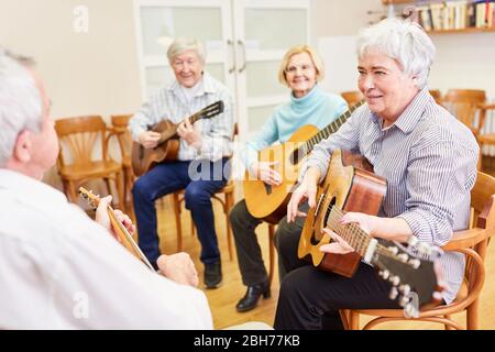 Group of seniors takes guitar lessons in the folk high school Stock Photo