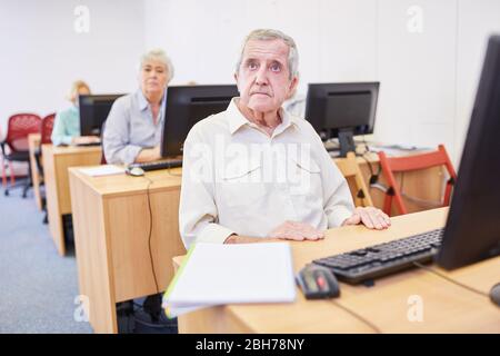 Seniors from the retirement home learn to use the Internet in a computer course at the VHS Stock Photo