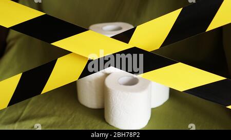 Stop panic - coronavirus. Rolls of Toilet paper behind the yellow tape