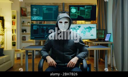 Cyber criminal wearing a white mask using augmented reality to steal secret information. Stock Photo