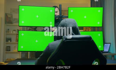 Team of dangerous hacker talking about how to attack the government. Computer with green screens. Stock Photo