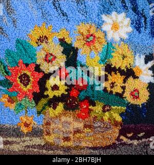 Basket with a bouquet of flowers, embroidered picture on the carpet. embroidery pattern. Stock Photo