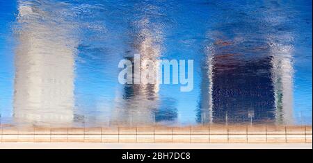 Blurry reflection silhouette of buildings on a water at sunny nice day, bright tone.Artistic urban background Stock Photo