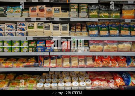 Dubai UAE December 2019 Different types of cheese on shelves in a grocery store. Shelf of packaged products, butter and cheese at a market. Cheddar, E Stock Photo