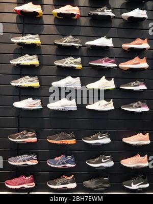 Shop display of a lot of Sports shoes on a wall. Wall of shoes inside ...