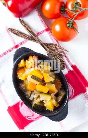 Food concept Homemade French organic Ratatouille in white bake ceramic bowl on blask slate stone board Stock Photo