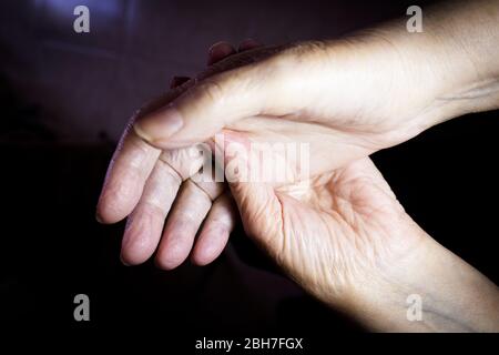 Hands of elderly woman doing a selfmassage. Manual physiotherapy Stock Photo