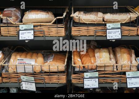 Different fresh bread on the shelves in bakery. Interior of a modern grocery store showcasing the bread aisle with a variety of prepackaged breads ava Stock Photo