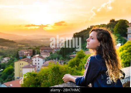 Chiusi, Italy cityscape town village rolling hills view in Tuscany and young woman looking at sunset view in summer Stock Photo