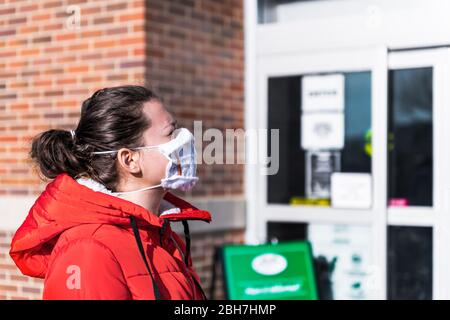 Social distancing of people waiting standing in line by grocery shop store entrance with woman in homemade furnace filter mask and frame during corona Stock Photo