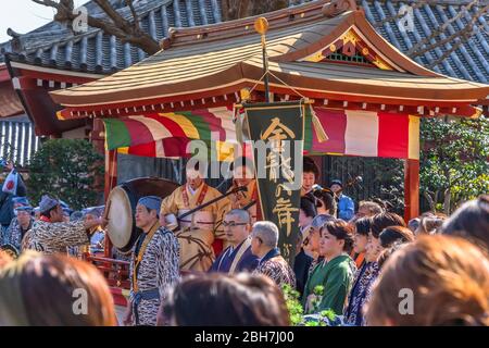 tokyo, japan - march 18 2020: Yatai cart overlooked by a buddhist temple's roof in which sit the Matsuri-bayashi music musicians played using the taik Stock Photo
