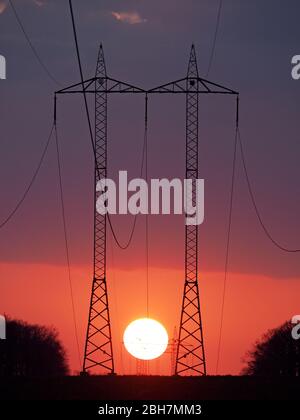 two towers of hight voltage during sunset Stock Photo