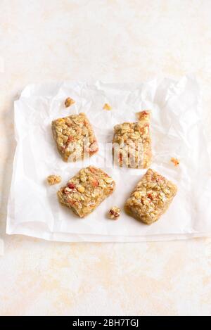 Honey no baked granola bar on paper over light stone background with free space. Natural healthy snack. Stock Photo