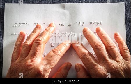 Close up photo of a woman hands reading braille text Stock Photo