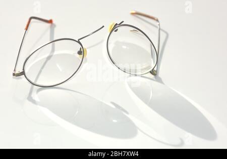 A pair of Titanium Wire Rim eye glasses that have broken and split apart on the nose bridge section. Stock Photo