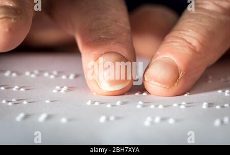 Close up photo of a woman hands reading braille text Stock Photo