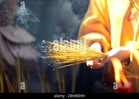 07.12.2019, Macao, , China - lit incense sticks in one hand. 00S191207D208CAROEX.JPG [MODEL RELEASE: NO, PROPERTY RELEASE: NO (c) caro images / Sorge, Stock Photo