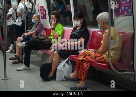 02.04.2020, Singapore, , Singapore - Passengers in a subway are wearing respiratory masks to protect themselves from infection with the pandemic coron Stock Photo