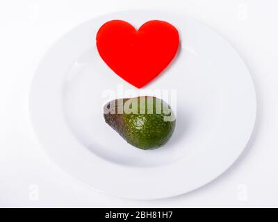 Red Heart With Avocado On White Plate Stock Photo
