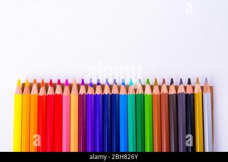 Colored Wooden Pencils In A Row Against White Background Stock Photo