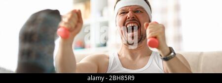 Guy doing exercises with dumbbells in his hands Stock Photo
