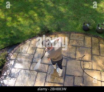 Man pressure washing patio from above Stock Photo