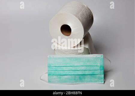still life of two rolls of toilet paper on white background with surgical mask Stock Photo